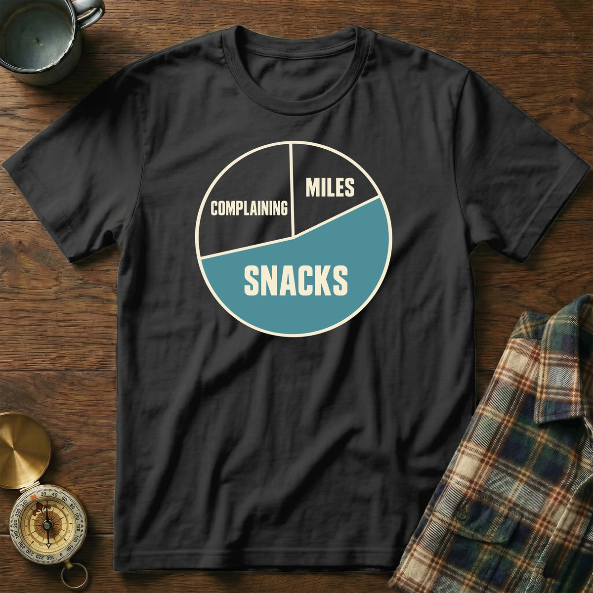 Black t-shirt with a pie chart graphic labeled "Complaining," "Miles," and "Snacks."