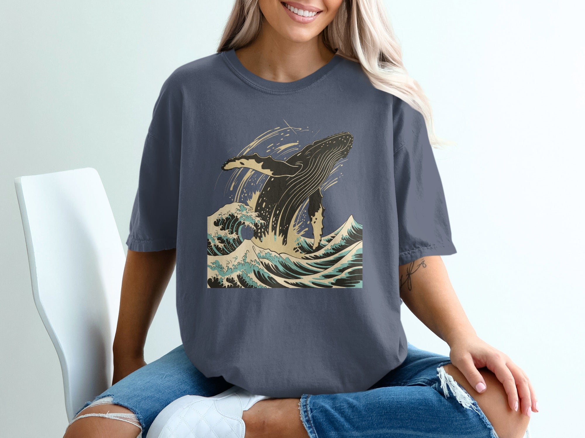 Dark blue t-shirt with a leaping whale and crashing waves graphic.