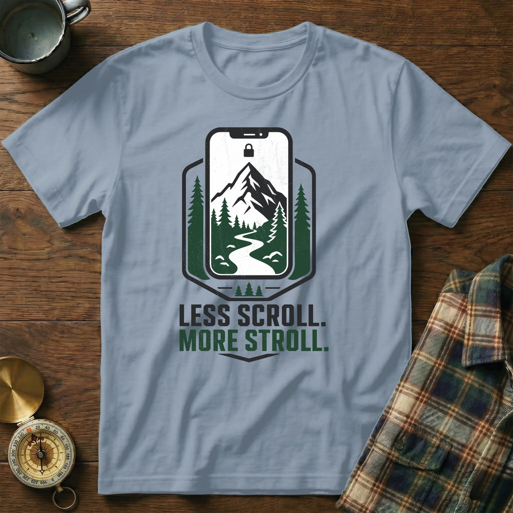 Light blue t-shirt with a screen print of a mountain landscape within a phone outline and text "LESS SCROLL. MORE STROLL."