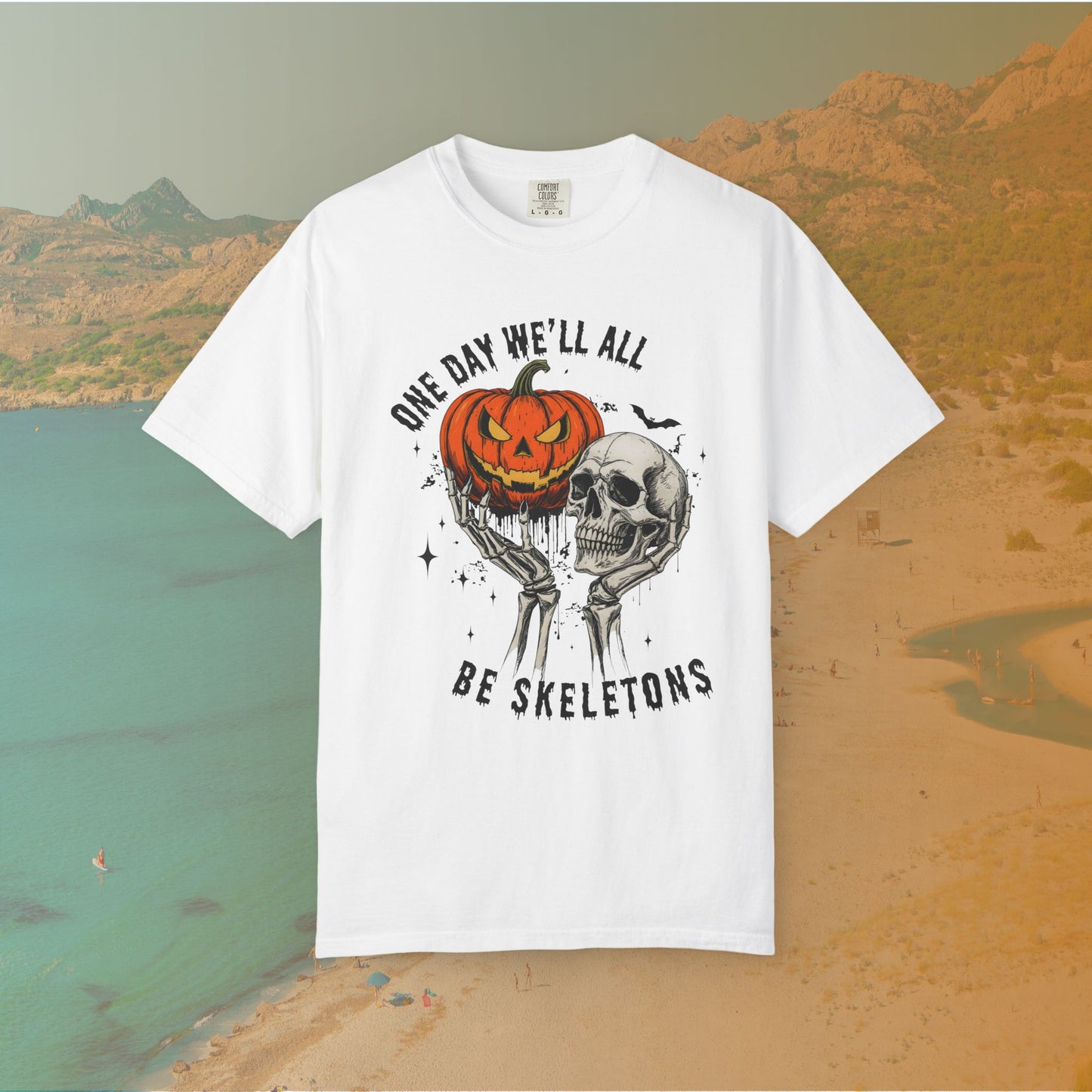 Skeleton hands holding a jack-o'-lantern and skull with the phrase ‘One Day We’ll All Be Skeletons’ in grunge font