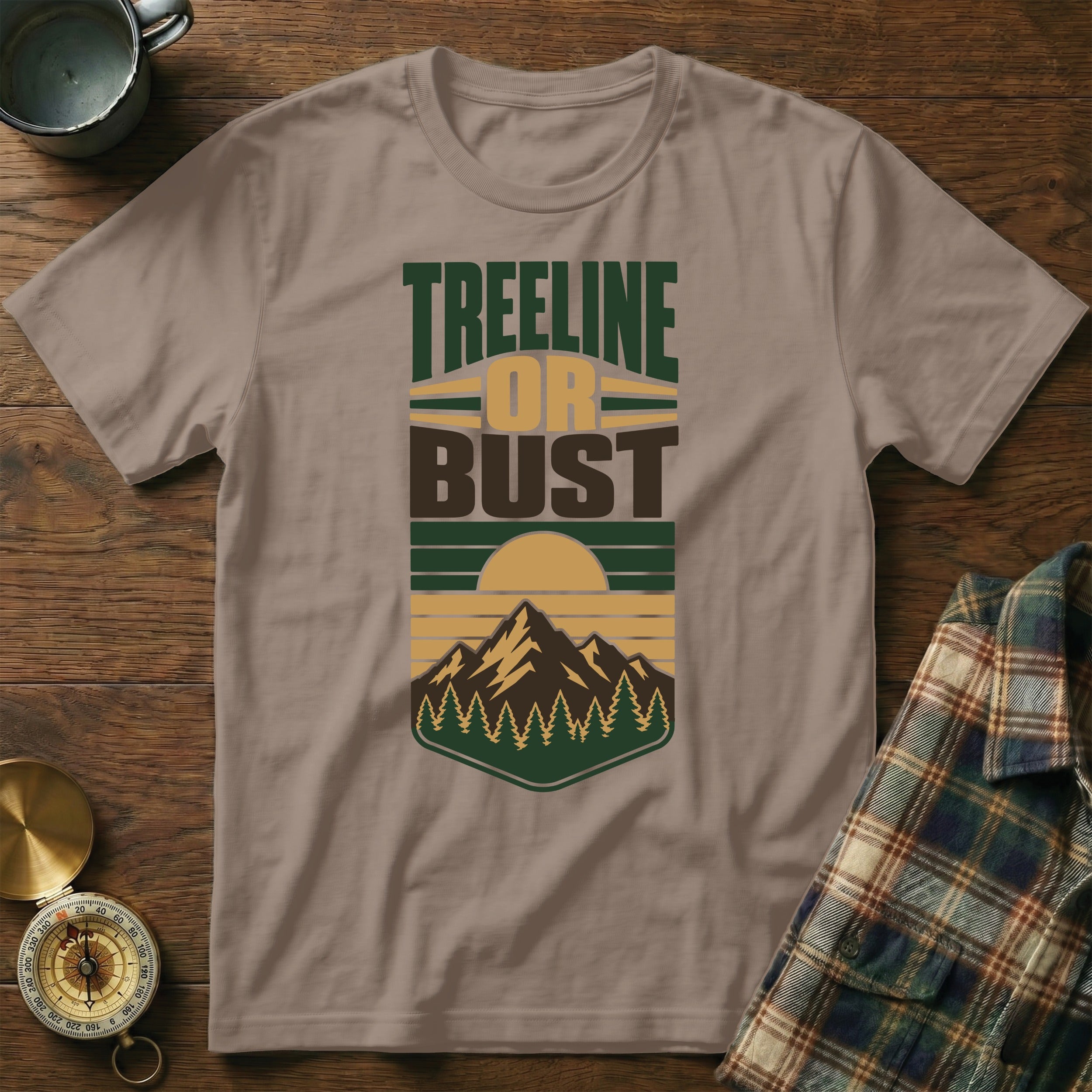 Brown t-shirt with graphic text "Treeline Or Bust" and mountain sunset design.