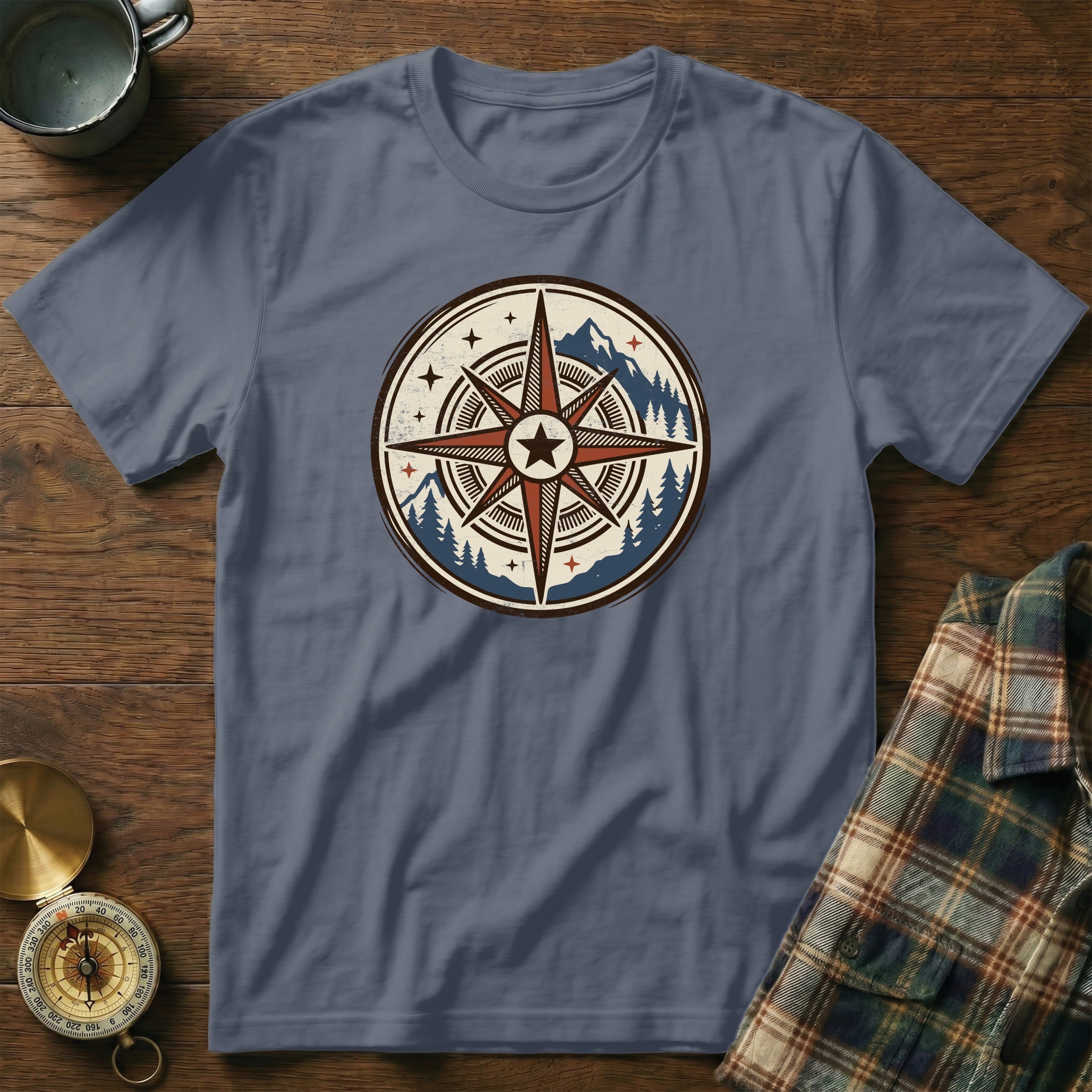 Grey t-shirt with a circular compass design featuring mountains and pine trees.