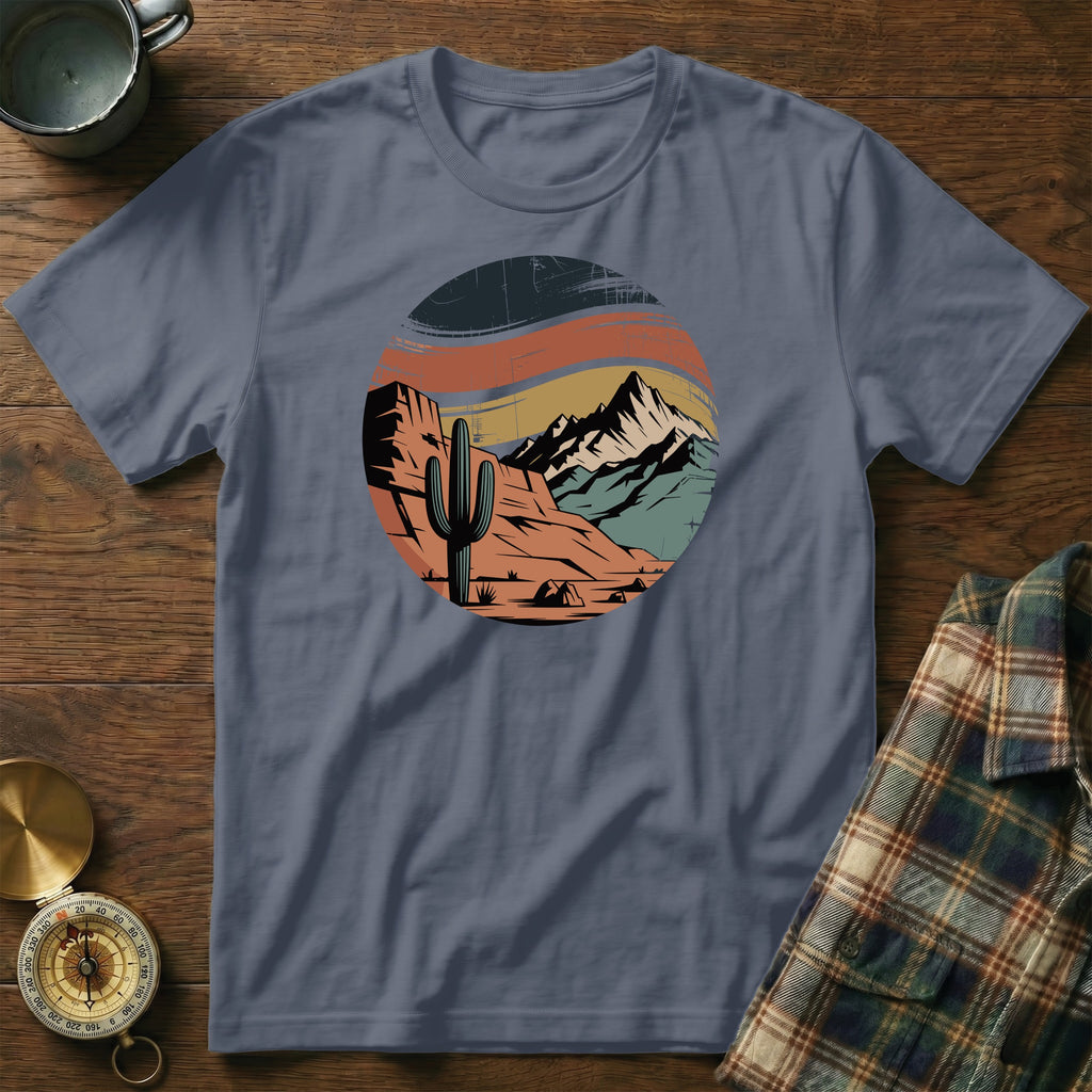 Circular desert landscape graphic with cactus and mountains on a grey t-shirt.