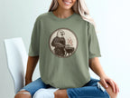 Eagle wearing apron, grilling with tongs on a charcoal grill design.