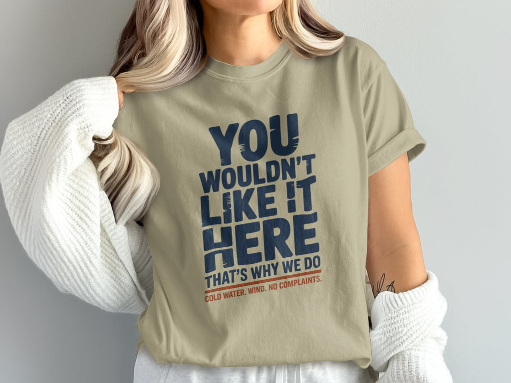 Beige t-shirt with "YOU WOULDN'T LIKE IT HERE" and "COLD WATER. WIND. NO COMPLAINTS." text.