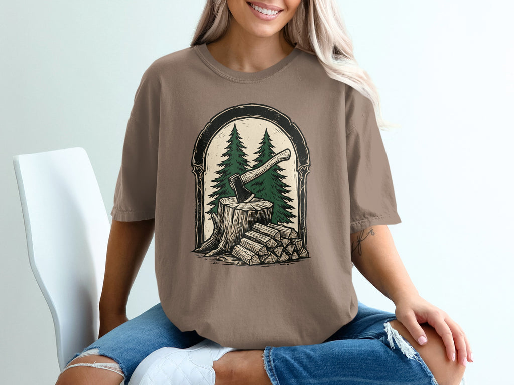T-shirt with axe, tree stump, and woodpile graphic inside arched frame.