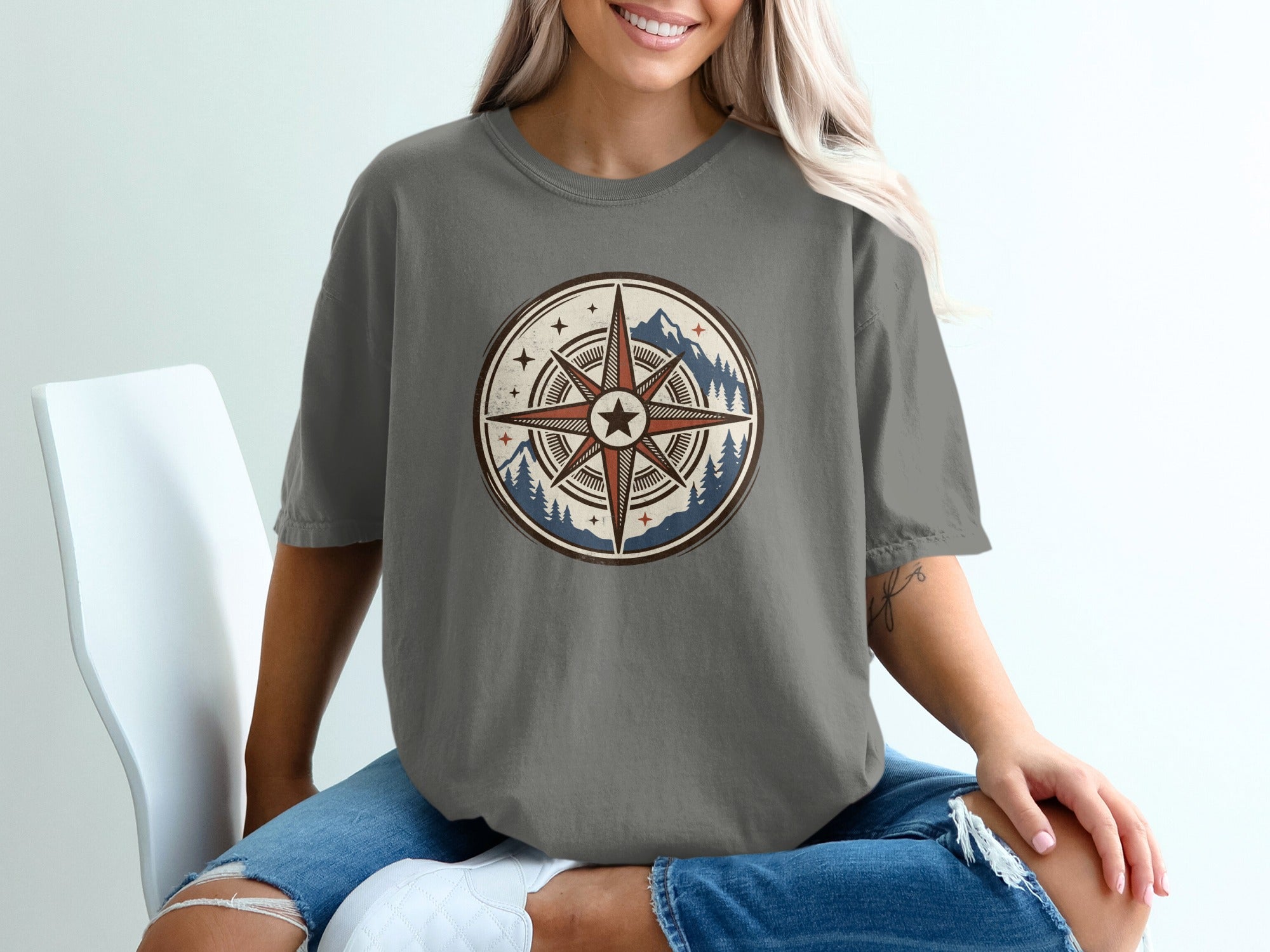 Grey t-shirt with circular compass and mountain graphic on the front.