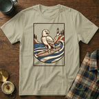 Eagle surfing on a surfboard with lighthouse and ocean graphic on t-shirt.