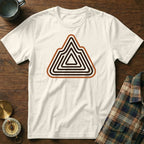 White t-shirt with brown and black mountain maze graphic on a wooden background.
