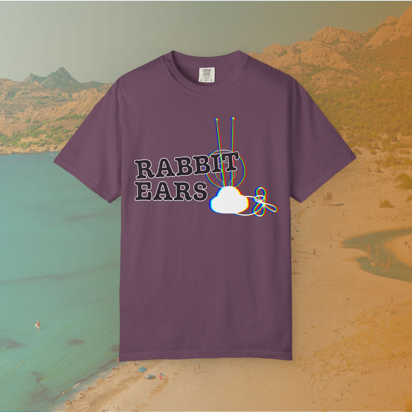 purple t-shirt distressed EDM music festival text "RABBIT EARS" next to a graphic of a vintage TV antenna and cloud shape with a red, green, and blue (RGB) chromatic aberration/glitch effect, with an RGB shift design