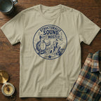 Tan t-shirt with a circular graphic of a turtle building a sandcastle, saying "Structurally Sound. Mostly."