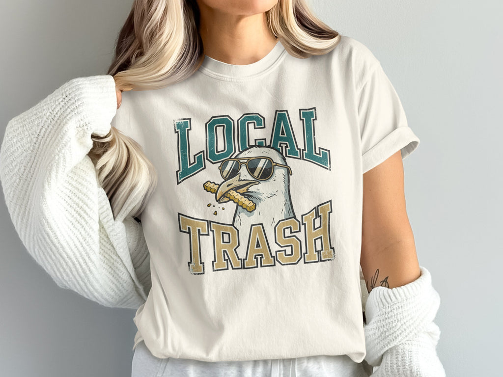 Cream t-shirt with a seagull wearing sunglasses and holding fries.
