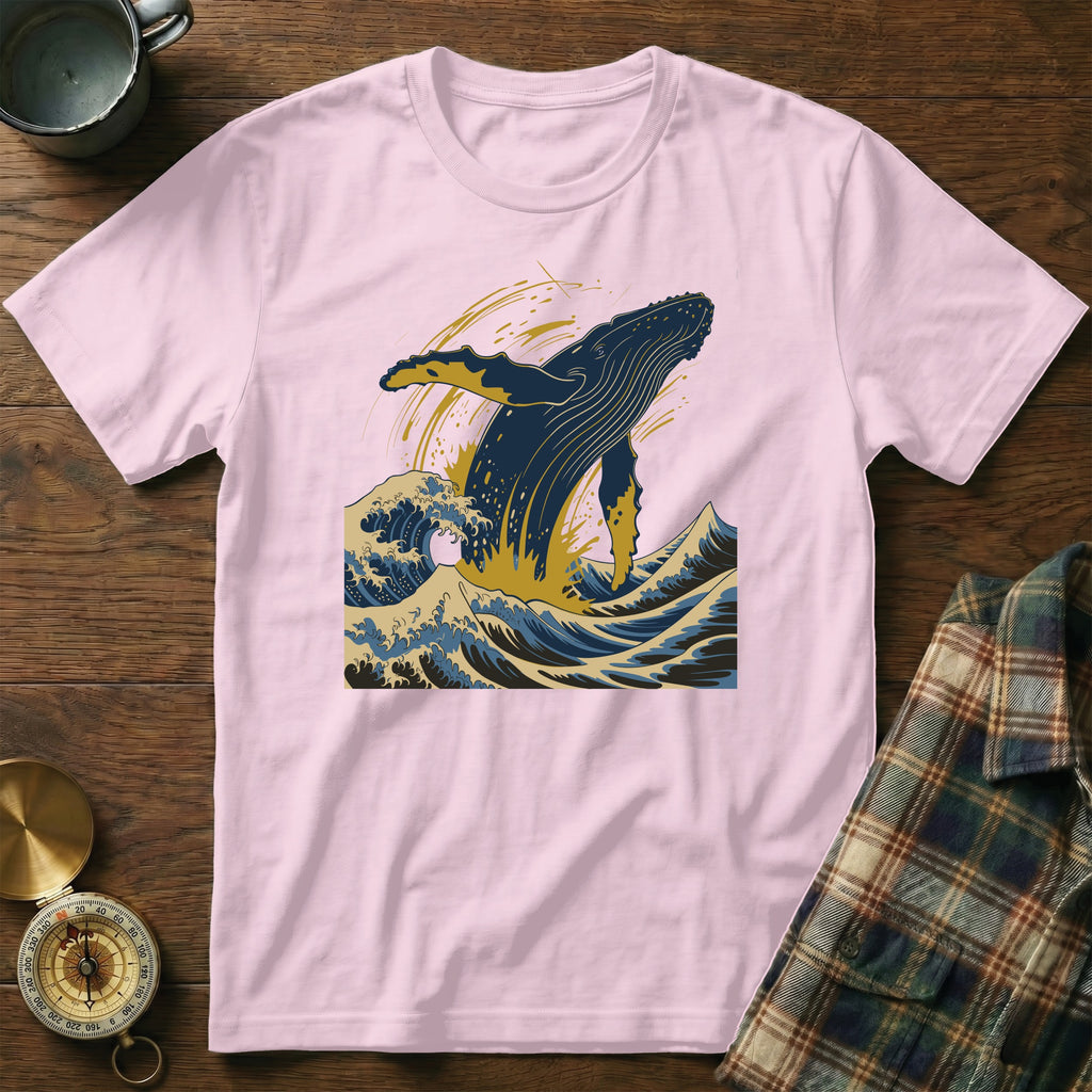 Pink t-shirt with a blue whale jumping through waves illustration.