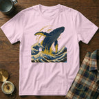 Pink t-shirt with a blue whale jumping through waves illustration.