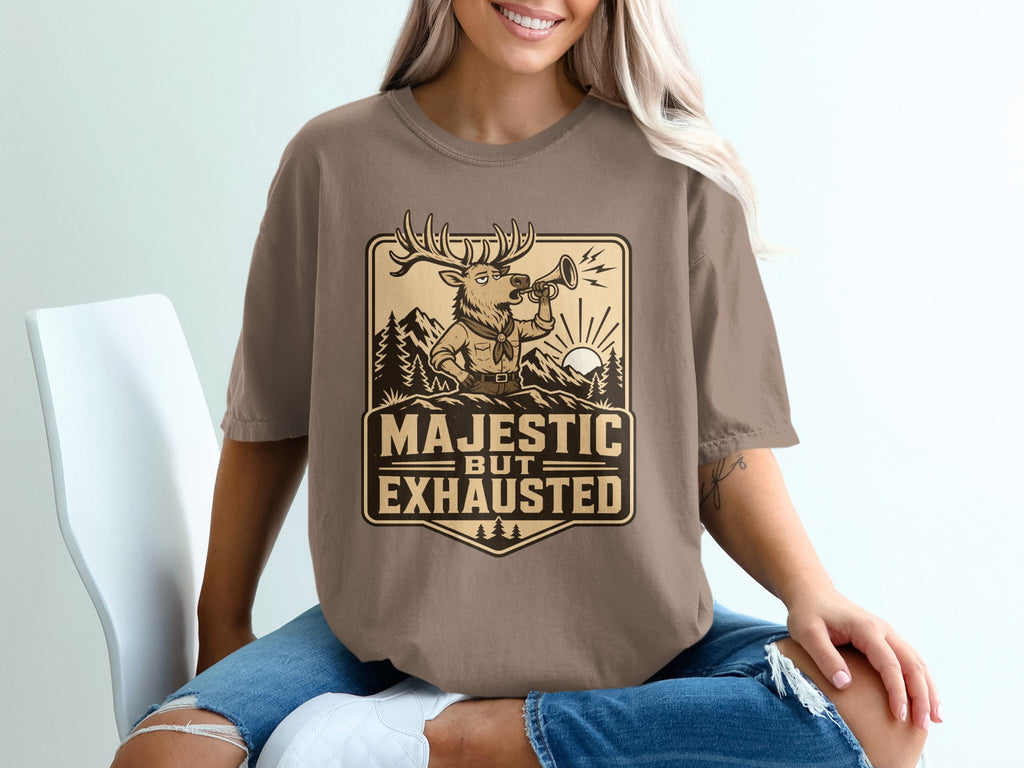 T-shirt with a deer blowing a horn within a crest reading "Majestic But Exhausted."
