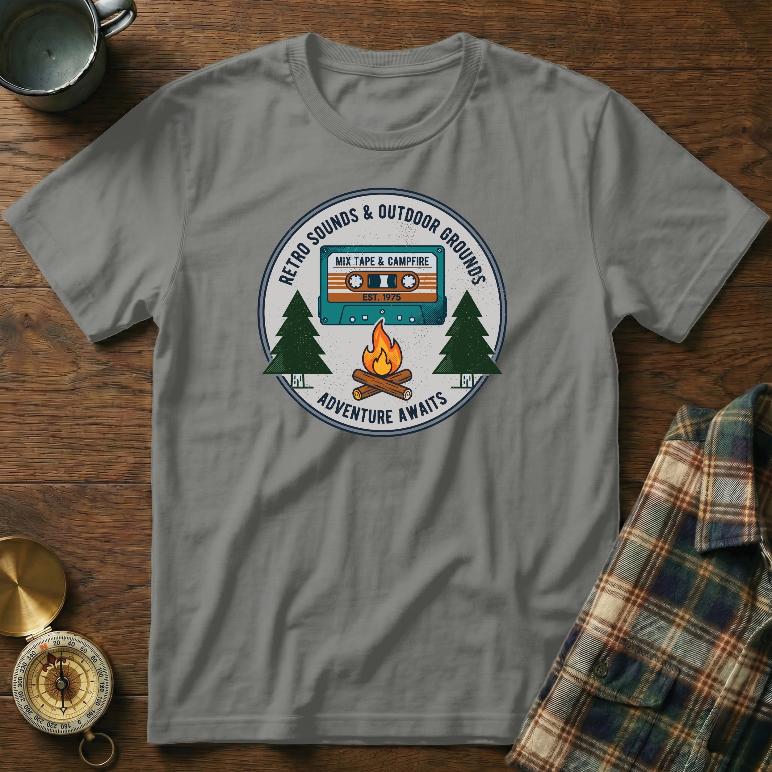 T-shirt graphic with retro cassette tape, campfire, trees, and text.