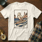 White t-shirt with a graphic of an eagle surfing, lighthouse, and waves.