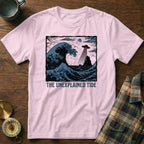 Pink t-shirt with "THE UNEXPLAINED TIDE" text and a UFO over a crashing wave.