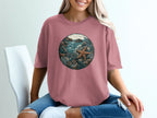 Round graphic of a starfish and seabed scene on a dusty rose t-shirt.