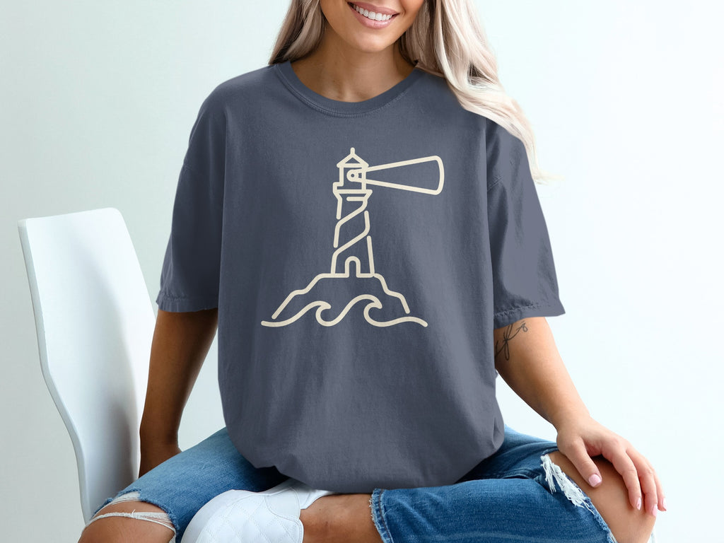 Dark gray t-shirt with a minimalist cream lighthouse and wave graphic.