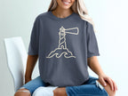 Dark gray t-shirt with a minimalist cream lighthouse and wave graphic.