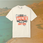 ivory Graphic T-shirt featuring the layered, distressed text: "I USED TO BE APATHETIC BUT NOW I JUST DON'T CARE," overlaid with halftone dot textures and boot print graphics.