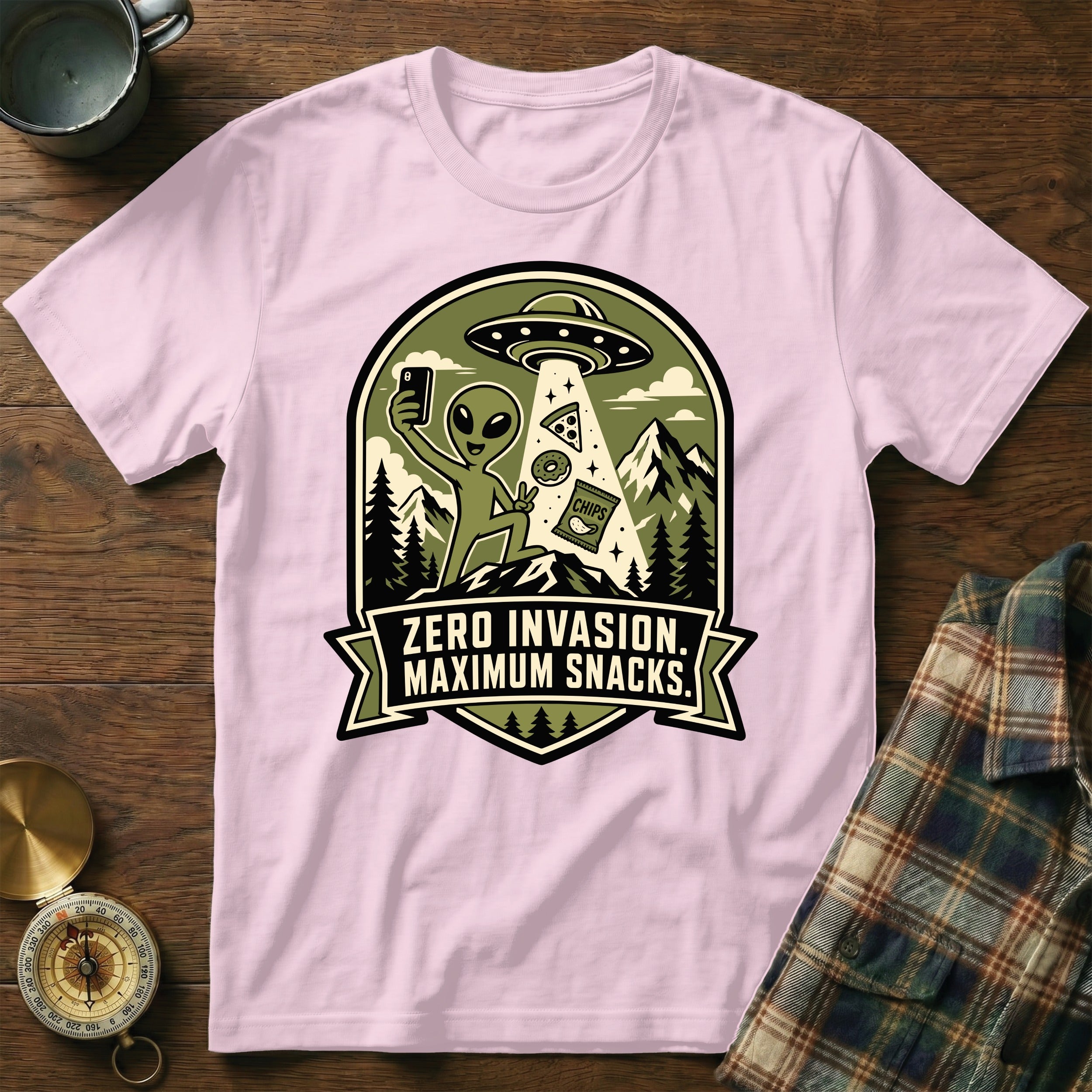 Pink t-shirt with alien taking selfie with snacks under UFO, says "Zero Invasion. Maximum Snacks."