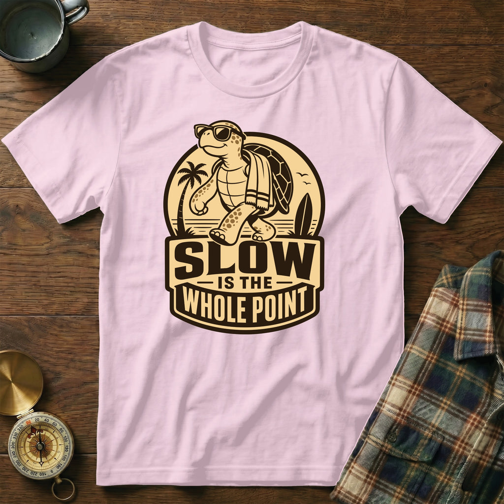 Pink t-shirt with cartoon turtle, sunglasses, towel, and text "SLOW IS THE WHOLE POINT".