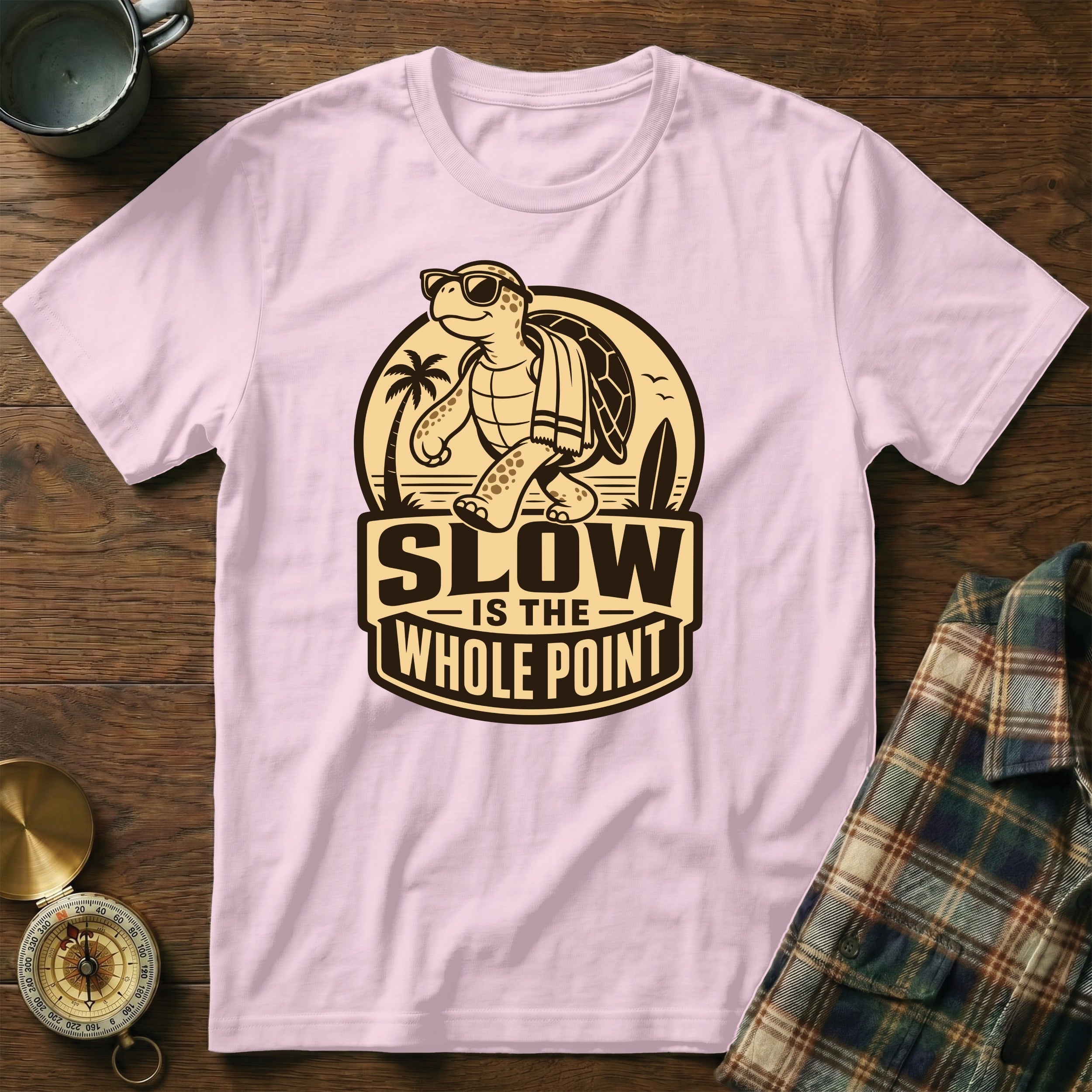 Pink t-shirt with cartoon turtle, sunglasses, towel, and text "SLOW IS THE WHOLE POINT".
