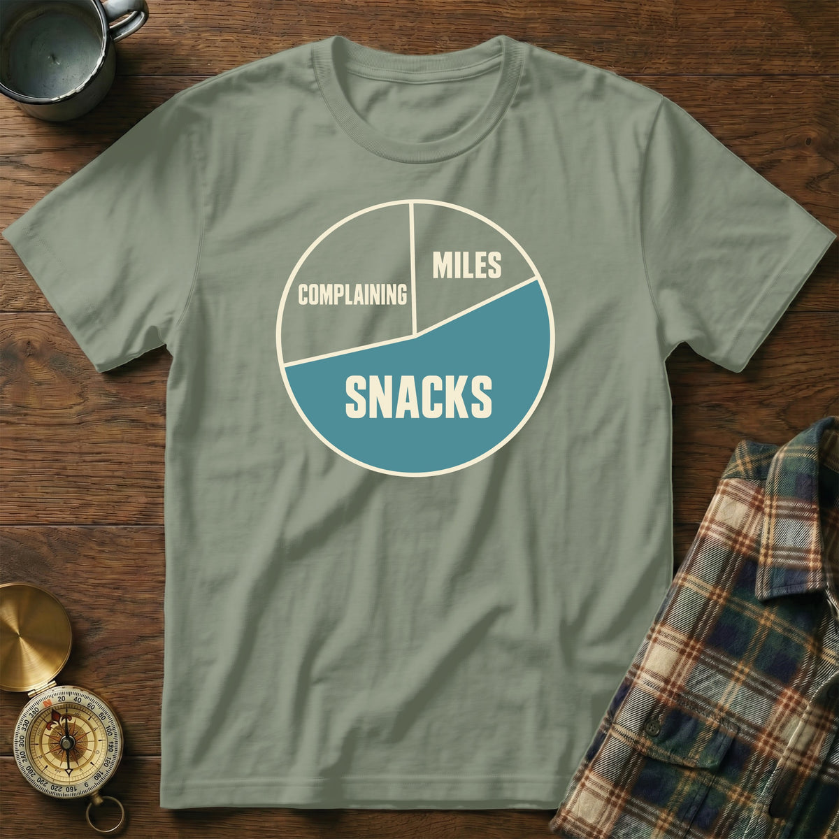 Green t-shirt with a pie chart graphic labeled "Complaining," "Miles," and "Snacks."