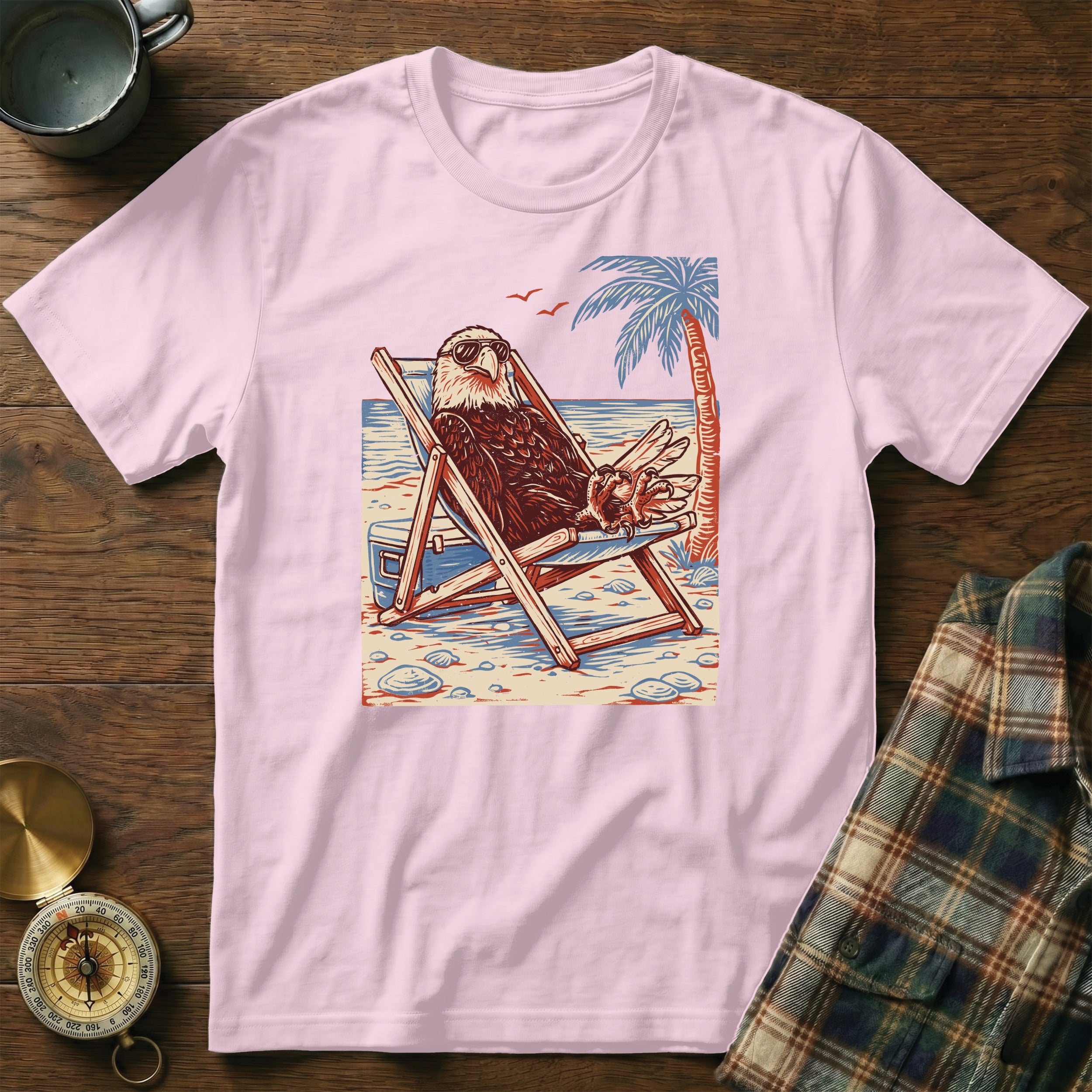 Bald eagle wearing sunglasses relaxes in a beach chair with a palm tree.