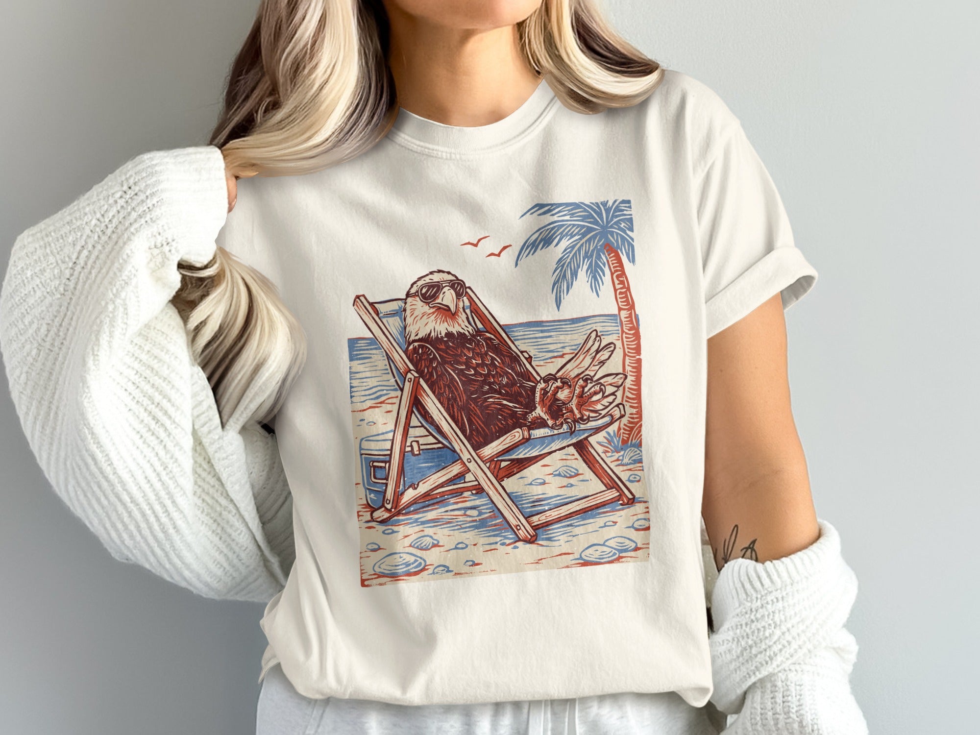 Eagle in sunglasses relaxing in a beach chair with palm tree.