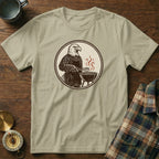 Graphic of eagle in apron grilling, on a tan t-shirt.
