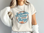 Cream t-shirt with circular design reading "Saltwater Fixes Most Things".