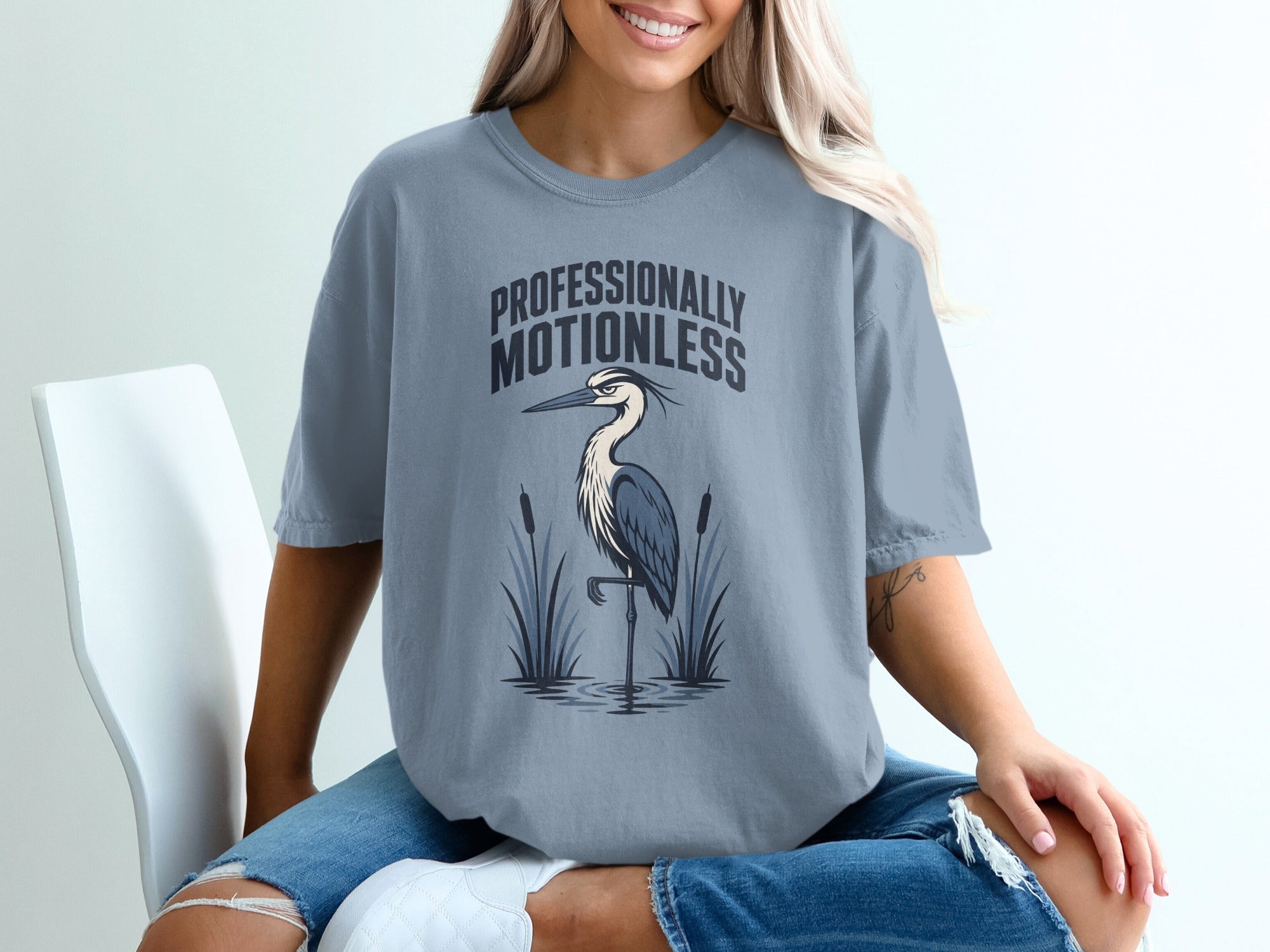 T-shirt with "Professionally Motionless" text and a heron standing in water.