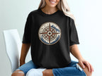 Black t-shirt with circular vintage compass design featuring mountains and trees.
