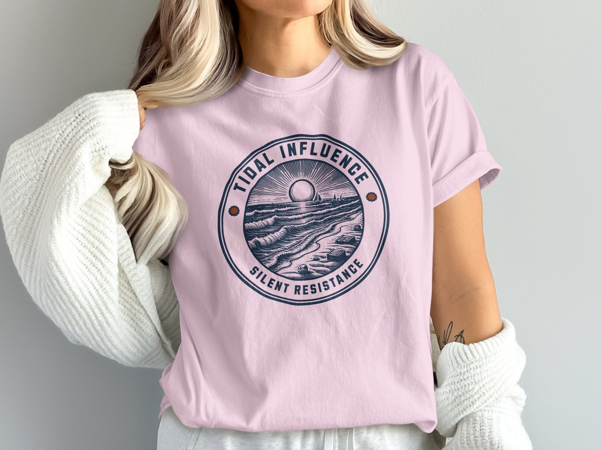 Pink t-shirt with "Tidal Influence Silent Resistance" logo featuring ocean waves and a sun.