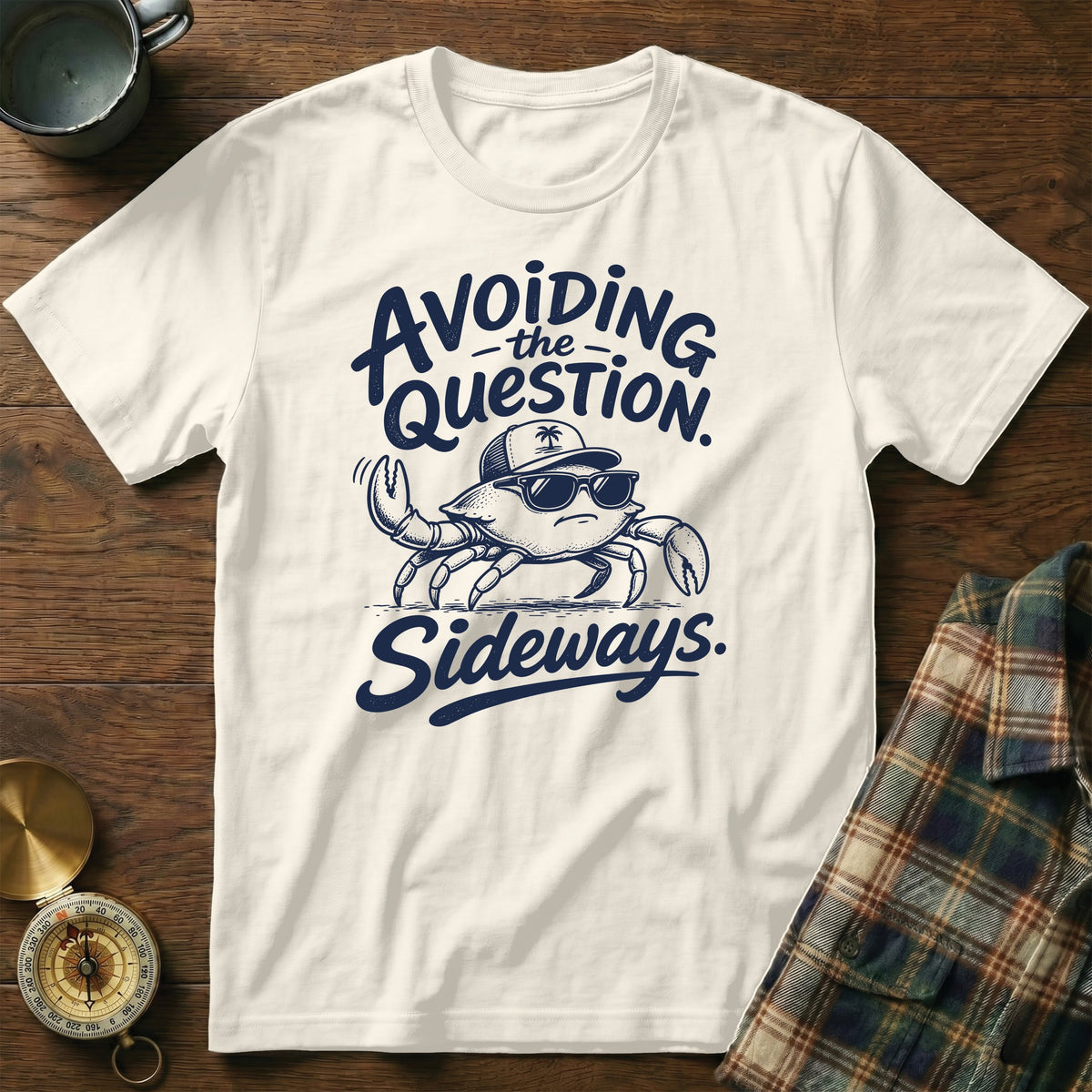 Off-white short-sleeve crewneck t-shirt featuring a blue graphic of a crab wearing sunglasses and a cap, accompanied by the text Avoiding the Question Sideways.
