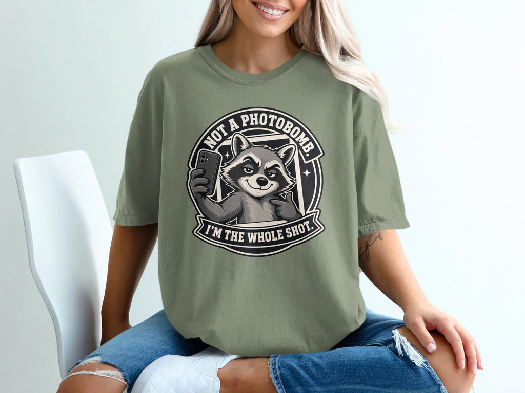 T-shirt graphic of a raccoon taking a selfie with text "Not a photobomb. I'm the whole shot."