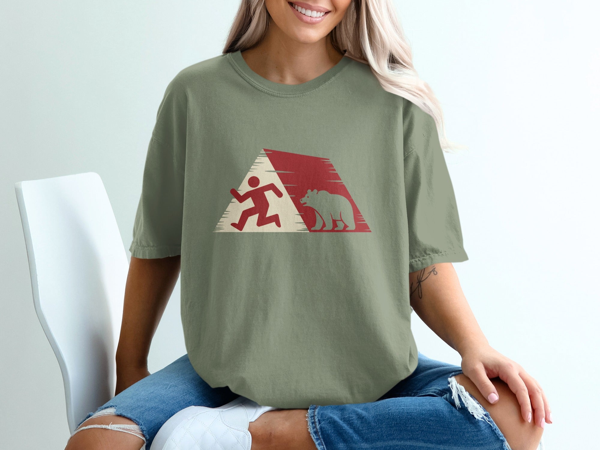 Running figure and bear silhouette against abstract geometric background on green t-shirt.