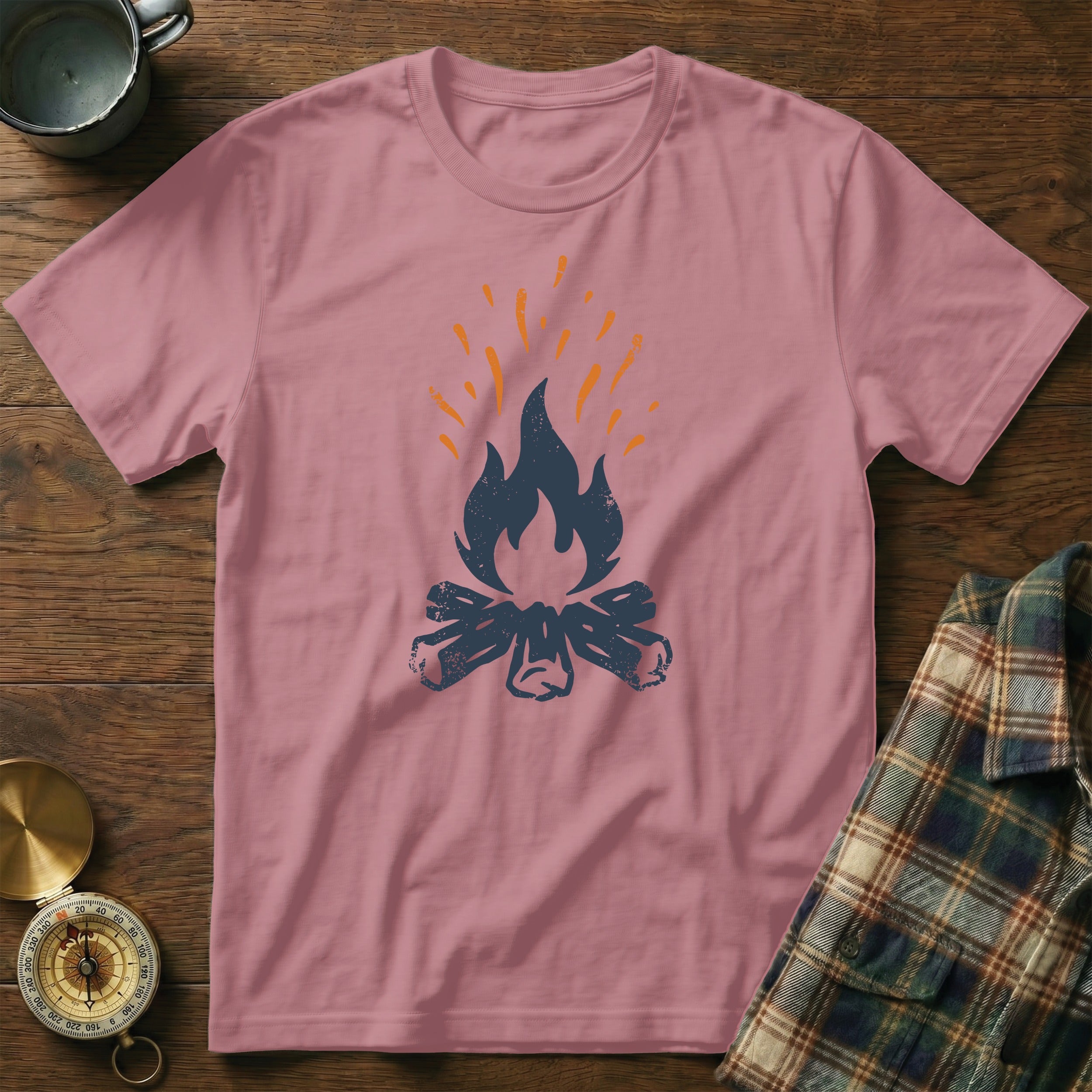 Pink t-shirt with a dark blue campfire graphic and orange flames.