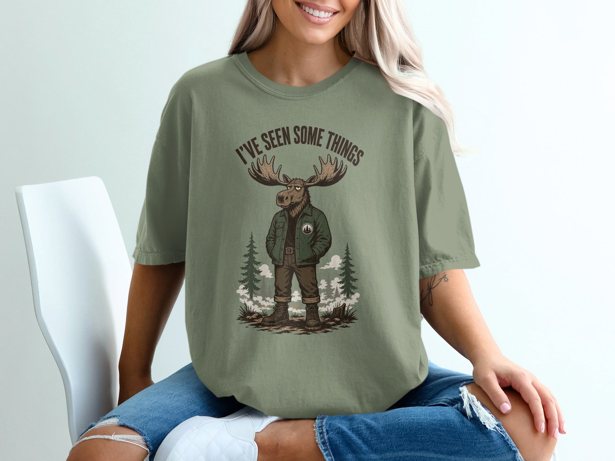 Green t-shirt with illustration of a moose in a jacket and text "I'VE SEEN SOME THINGS".