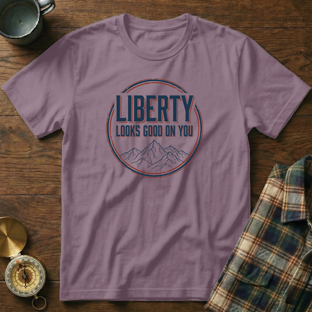 Purple t-shirt with "Liberty Looks Good On You" text and mountains graphic.