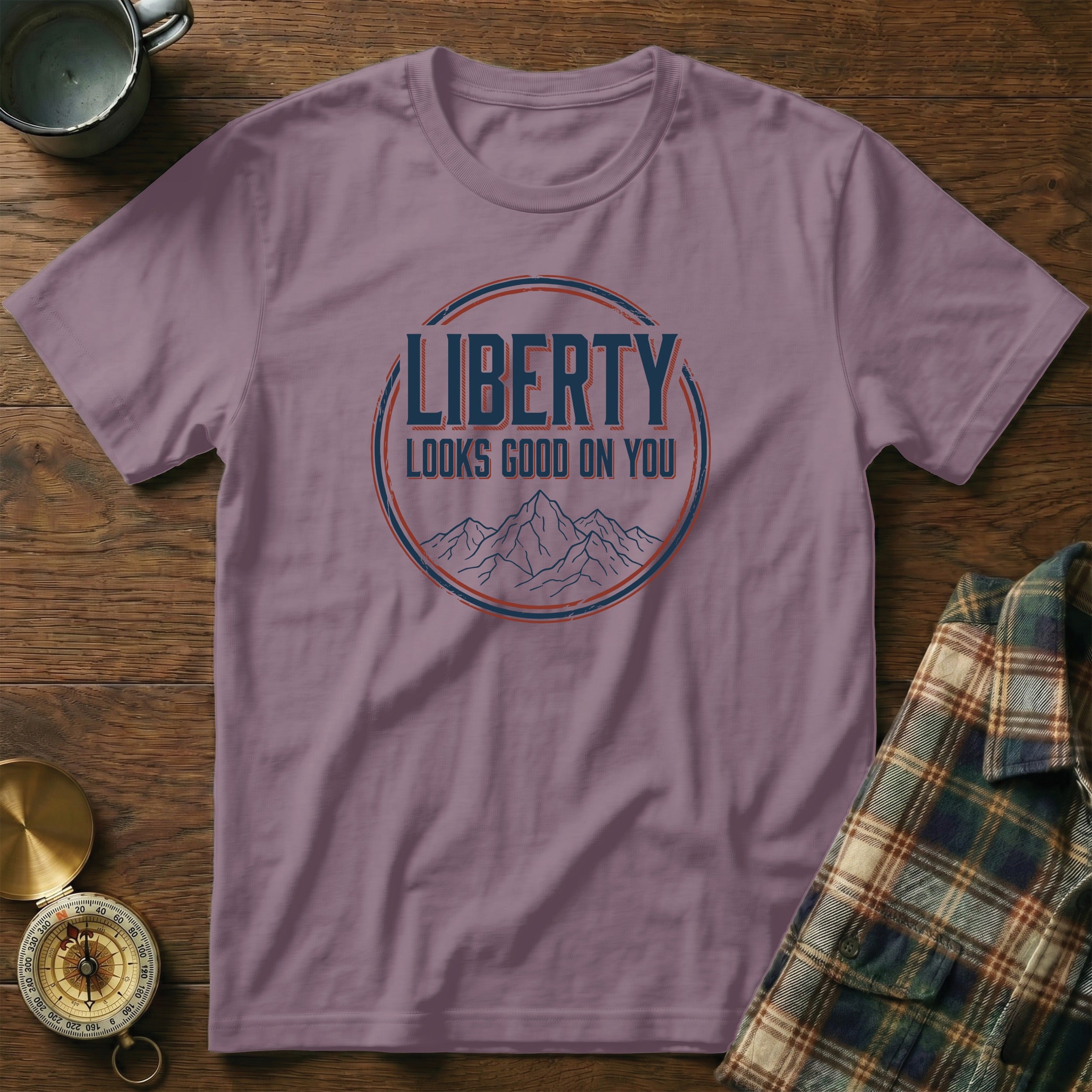 Purple t-shirt with "Liberty Looks Good On You" text and mountains graphic.