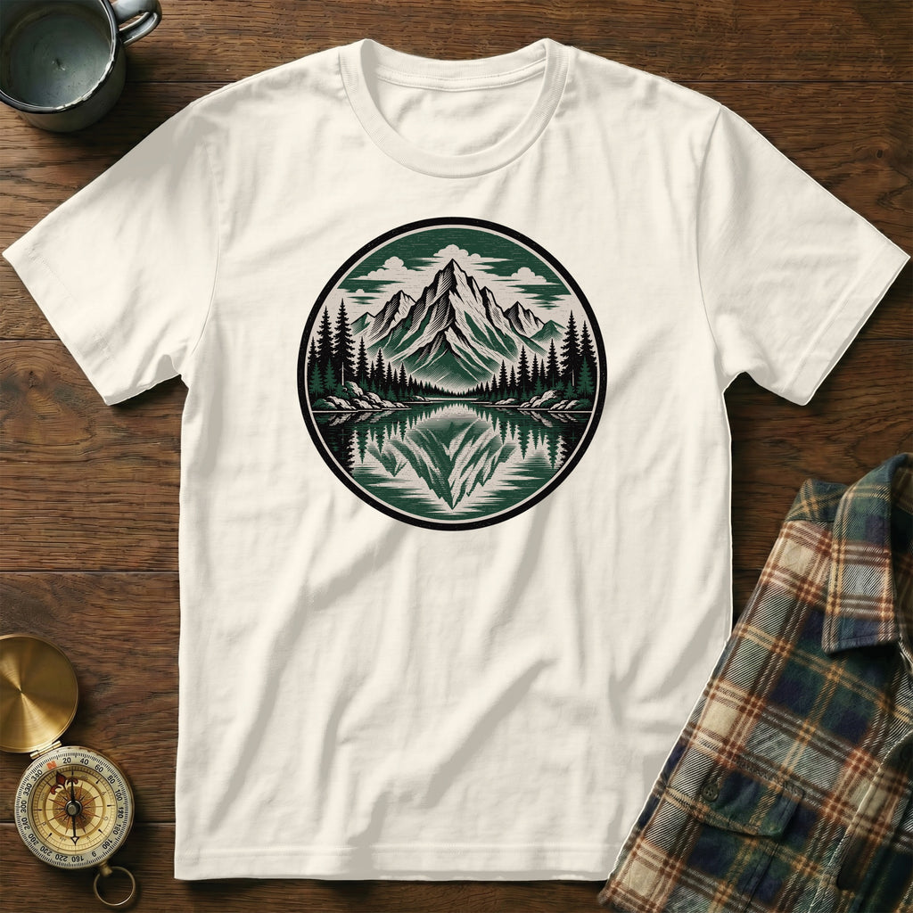 White t-shirt with a round mountain and forest scene graphic.