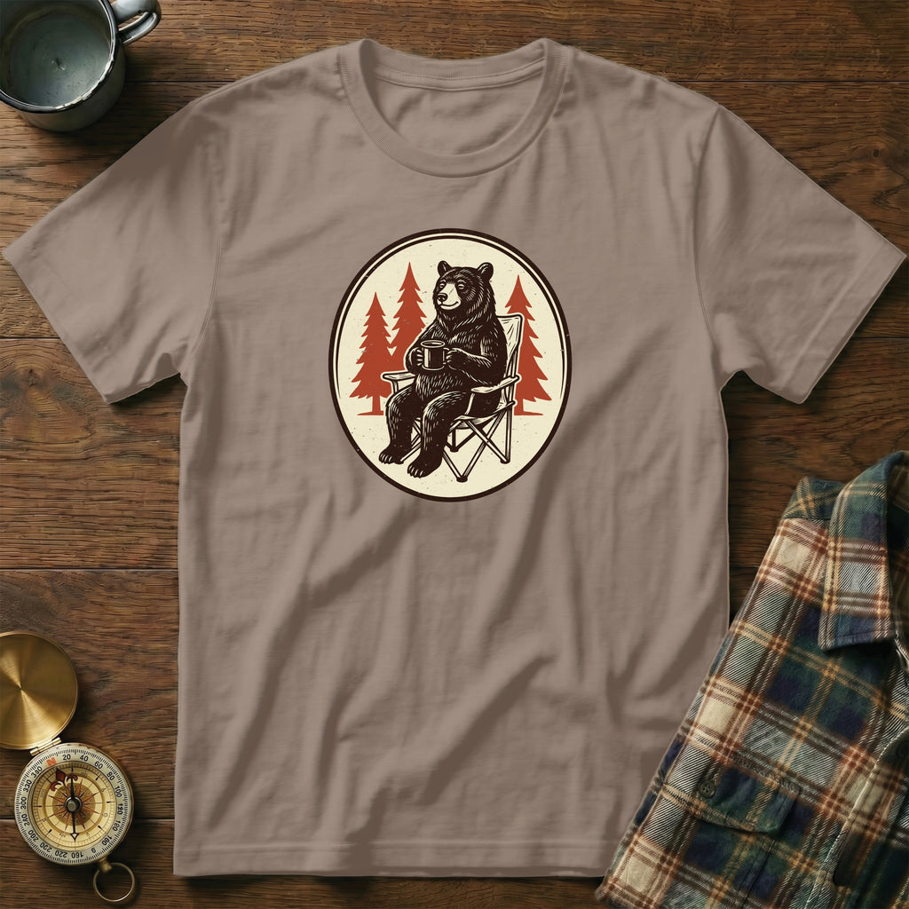 T-shirt with graphic of bear sitting in a chair holding a coffee mug.