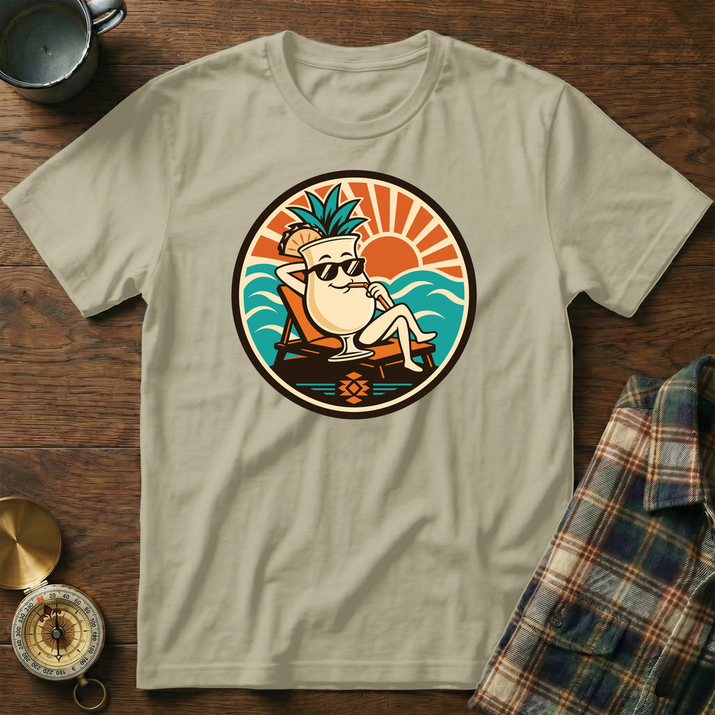 T-shirt featuring a cartoon cocktail with pineapple relaxing on a beach chair.