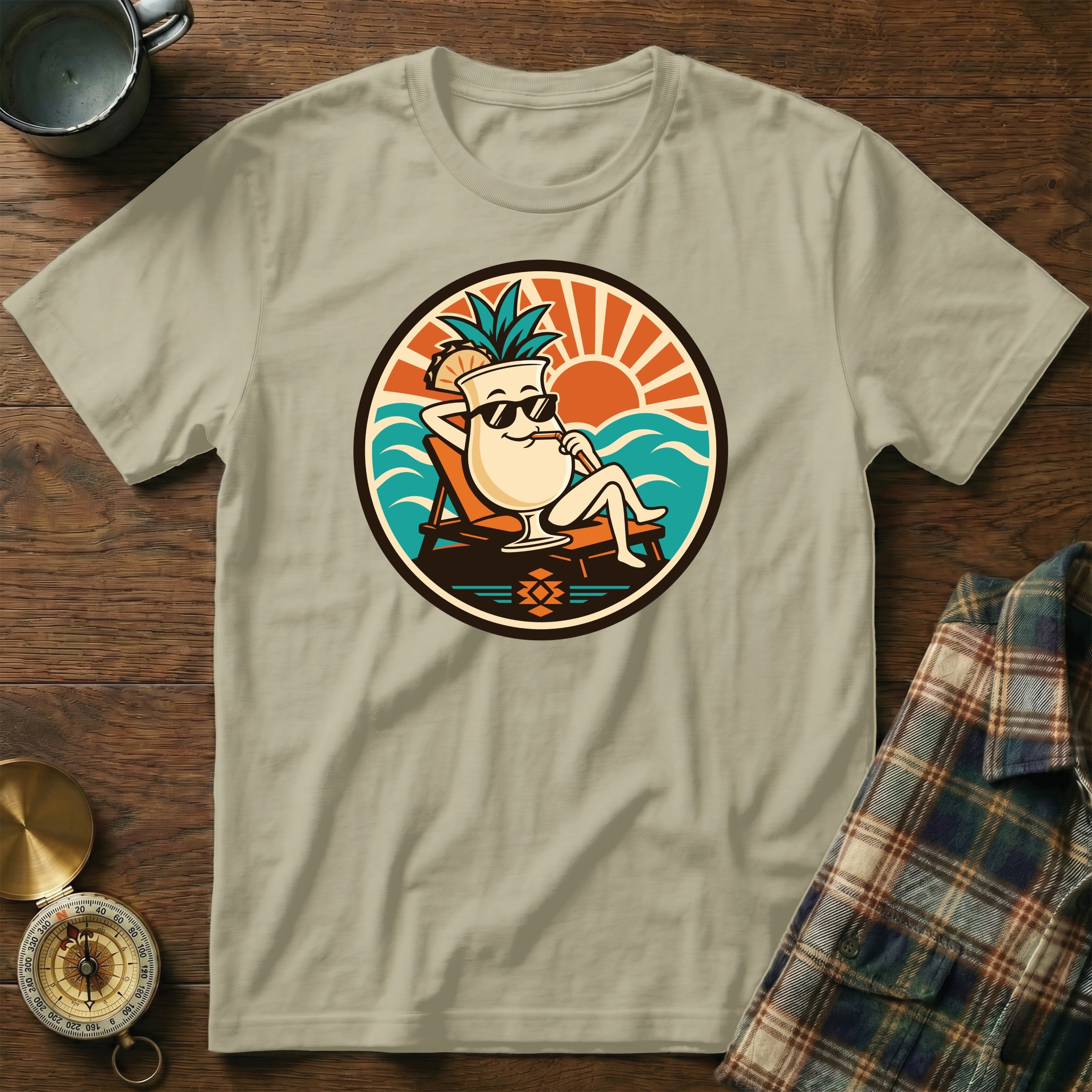 T-shirt featuring a cartoon cocktail with pineapple relaxing on a beach chair.
