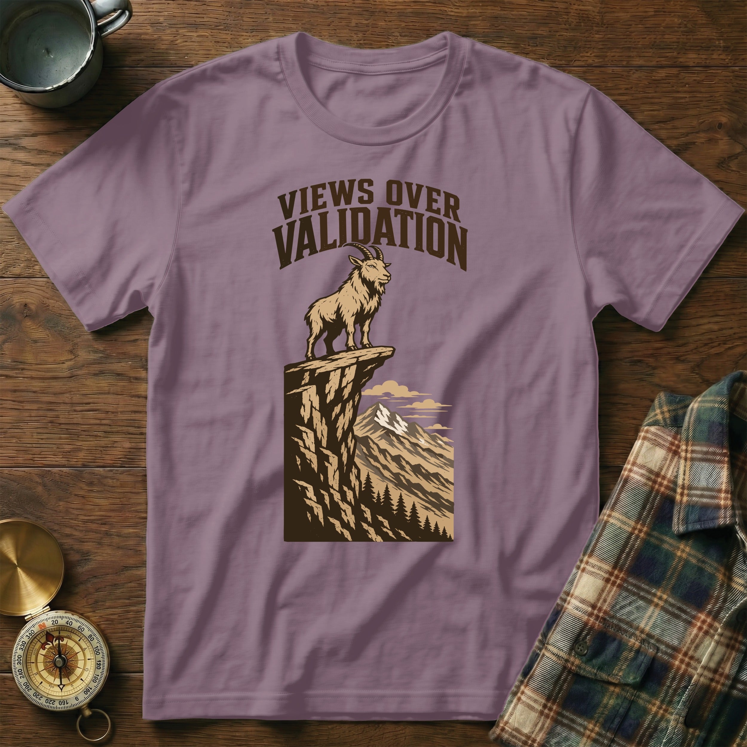 Purple t-shirt with graphic of goat on cliff, text "Views Over Validation".