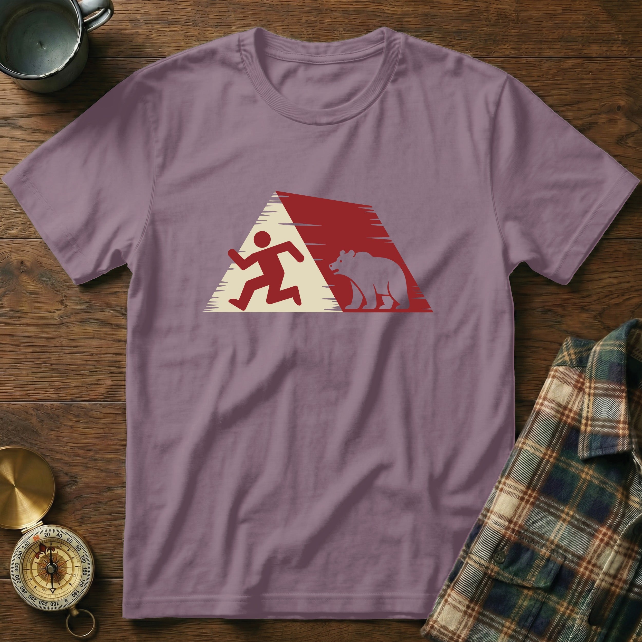 Running figure and bear silhouette inside a geometric mountain design on a purple t-shirt.